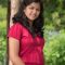 smiling woman in red shirt posing outdoors 2026 03 26 06 21 54 utc
